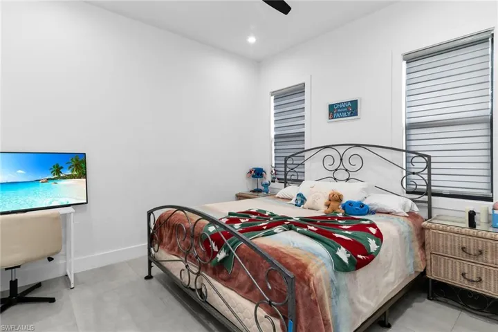 Bedroom with a ceiling fan, light tile patterned floors, and recessed lighting