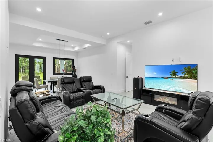 Living area featuring a raised ceiling and recessed lighting