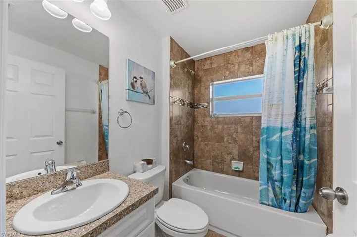 Bathroom with vanity and shower / tub combo with curtain