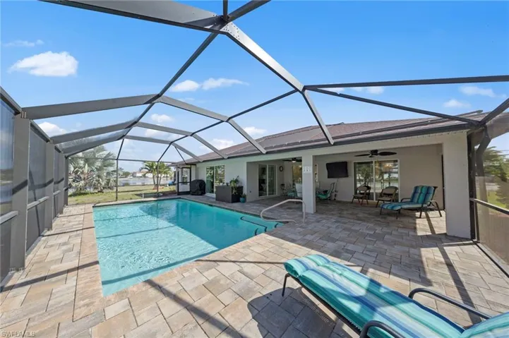 Swimming pool with a sunroom, glass enclosure, and a patio