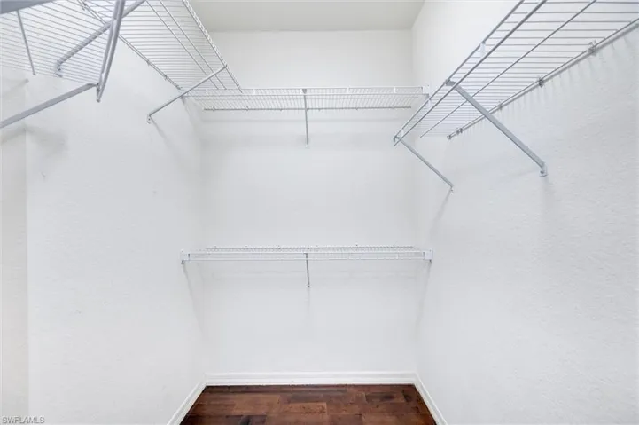 Spacious closet with dark wood-style flooring