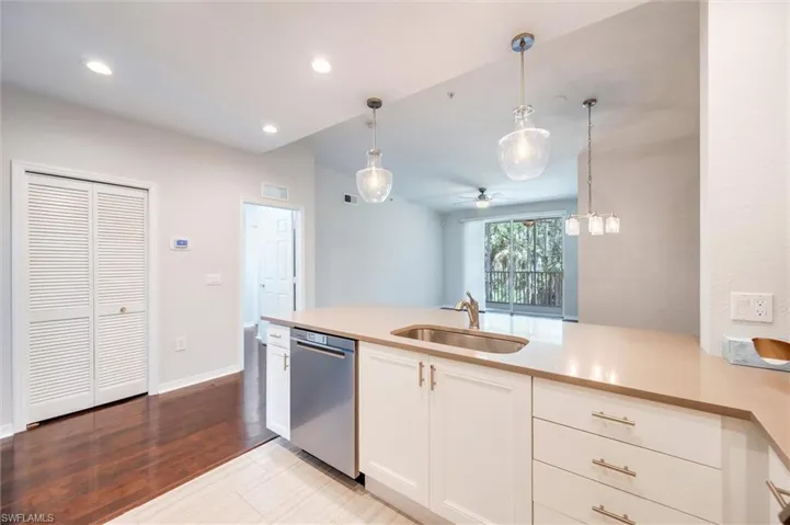 Kitchen with stainless steel dishwasher, a ceiling fan, pendant lighting, white cabinetry, and light countertops