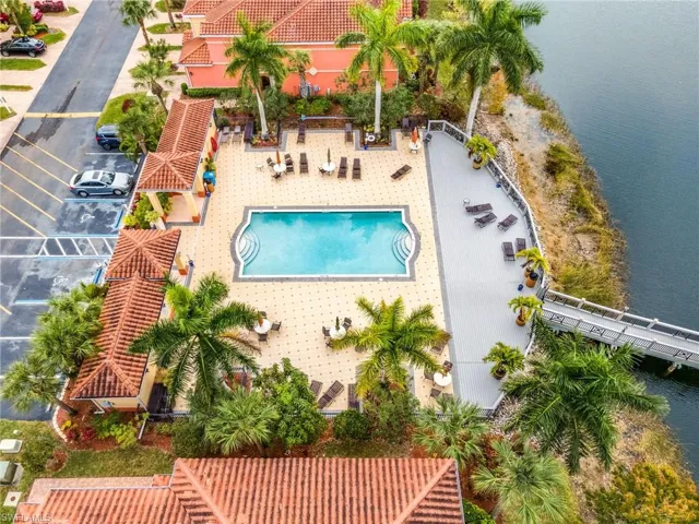 Aerial view of property and surrounding area featuring a pool and a large body of water
