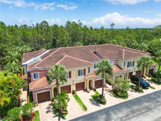 Mediterranean / spanish-style house with a tiled roof, driveway, a garage, and stucco siding