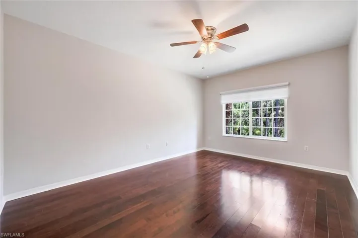 Spare room with dark wood finished floors and ceiling fan