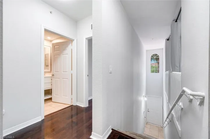Hall featuring wood-type flooring and an upstairs landing
