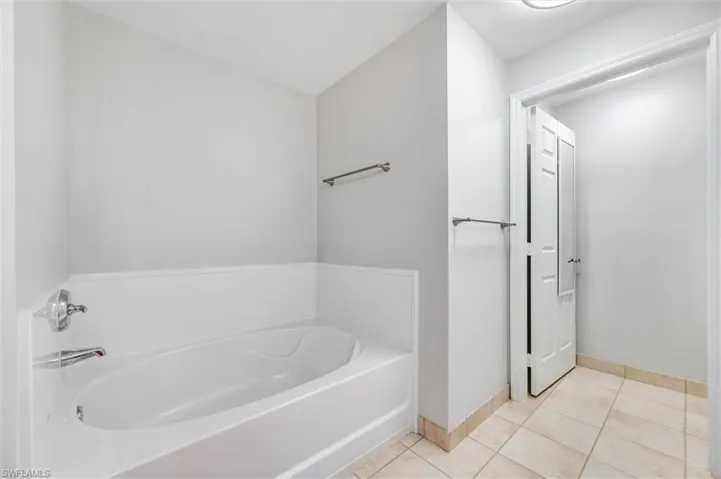 Full bathroom featuring a garden tub and tile patterned flooring