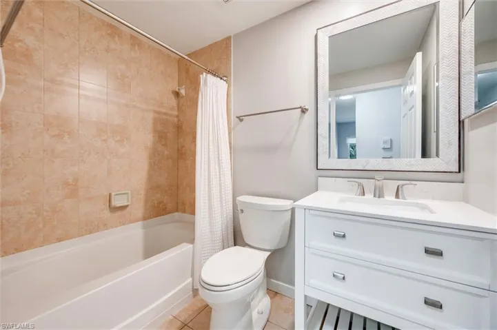 Full bath with vanity, shower / bath combo, and tile patterned floors