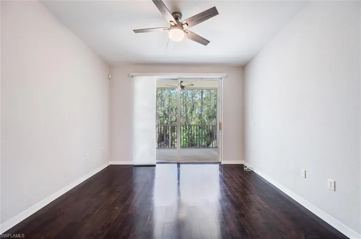 Spare room with ceiling fan and dark wood-type flooring