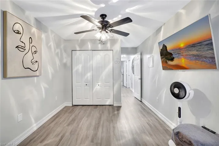 Bedroom featuring wood finished floors, a closet, and a ceiling fan