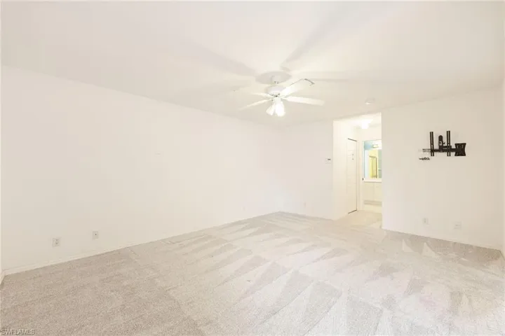 Unfurnished room with ceiling fan and light colored carpet