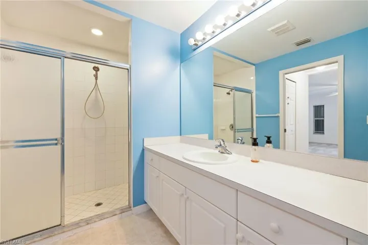 Bathroom featuring vanity, a shower with door, and tile patterned flooring