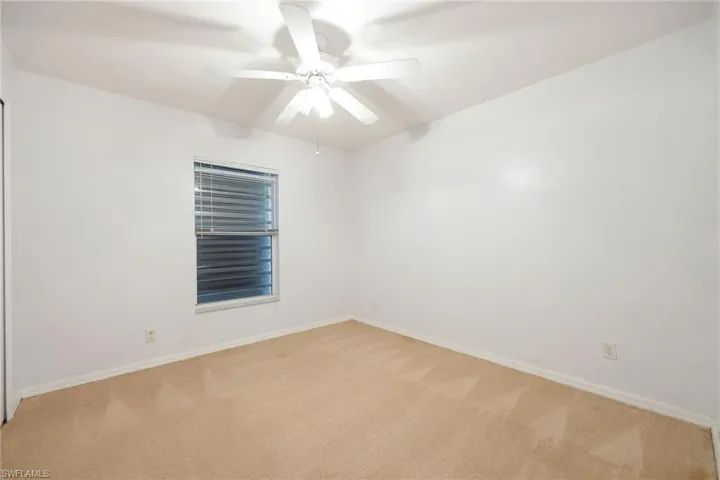 Unfurnished room with light colored carpet and ceiling fan
