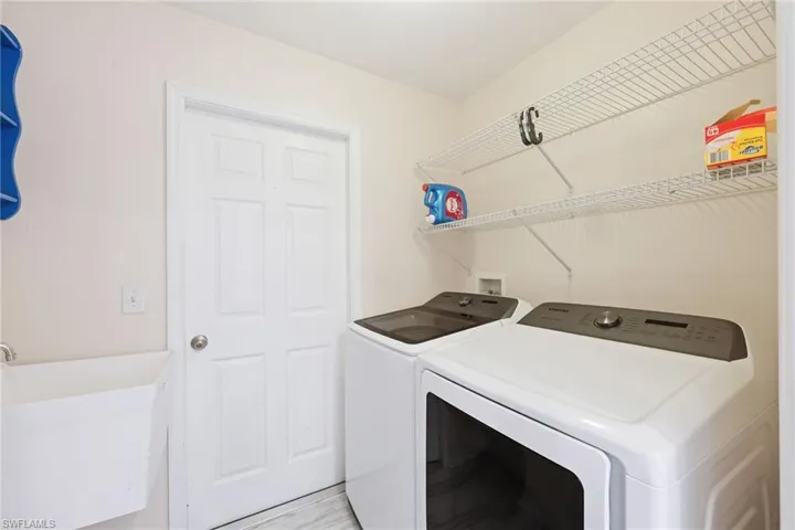 Washroom featuring separate washer and dryer, light hardwood / wood-style floors, and sink