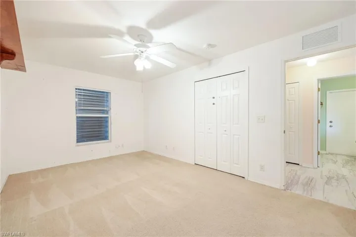 Unfurnished bedroom with ceiling fan and light carpet