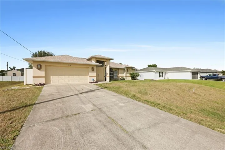 View of front of home with a garage and a front lawn