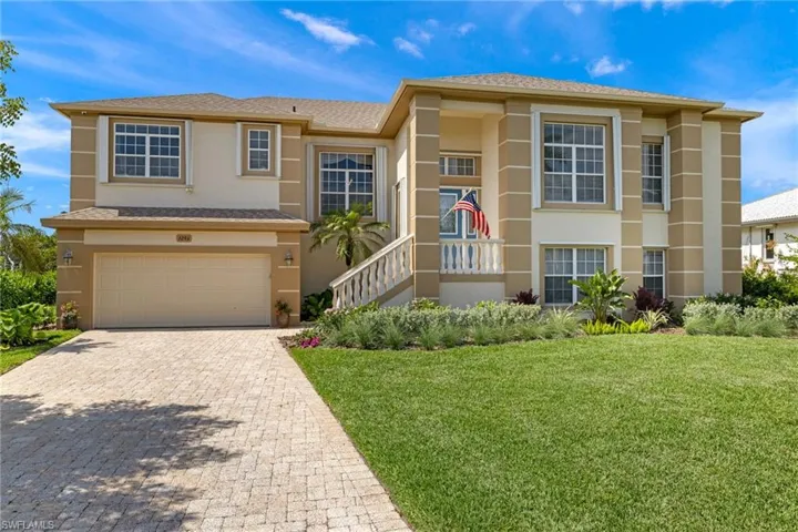 View of front facade with stucco siding, an attached garage, decorative driveway, a front lawn, and roof with shingles