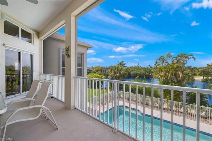 Balcony featuring view of pool and a water view