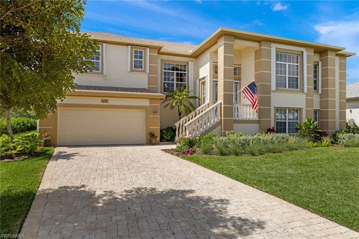 View of front of property with stucco siding, a garage, decorative driveway, a front lawn, and a shingled roof