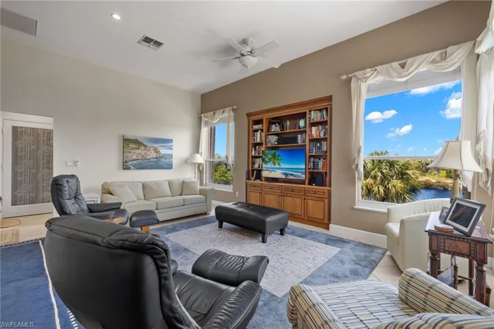 Living area with a ceiling fan, recessed lighting, and tile patterned flooring