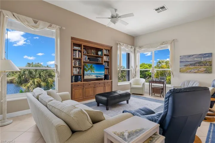 Living room with light tile patterned floors and ceiling fan