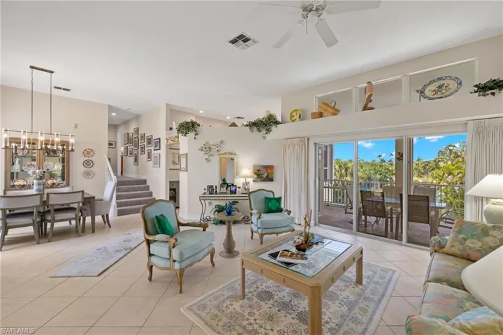 Living area with light tile patterned floors, stairway, recessed lighting, and a ceiling fan