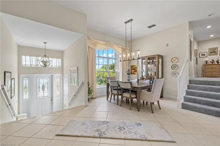 Dining space featuring a chandelier, stairs, and light tile patterned floors