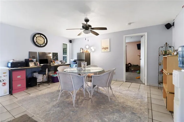 Dining area with light tile patterned flooring, baseboards, and a ceiling fan
