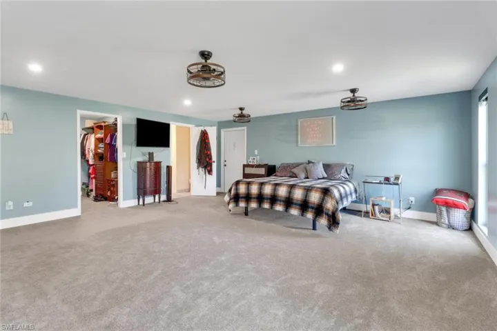 Bedroom with a closet, baseboards, a walk in closet, and recessed lighting