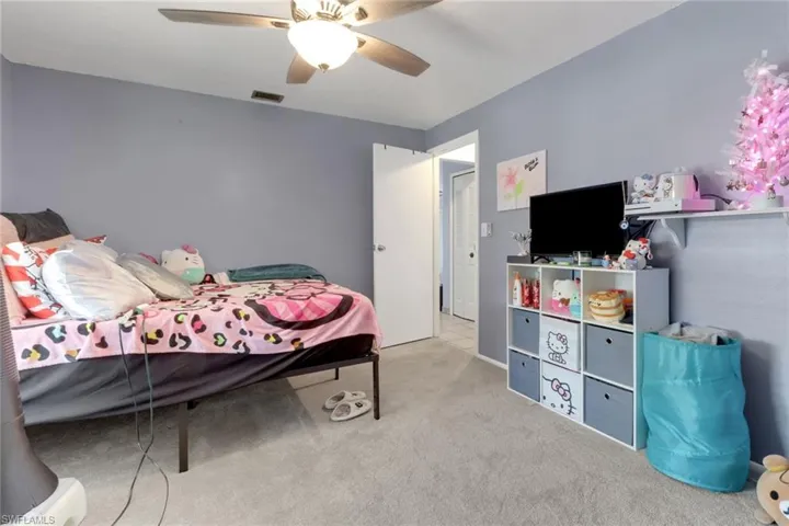 Carpeted bedroom featuring visible vents and a ceiling fan