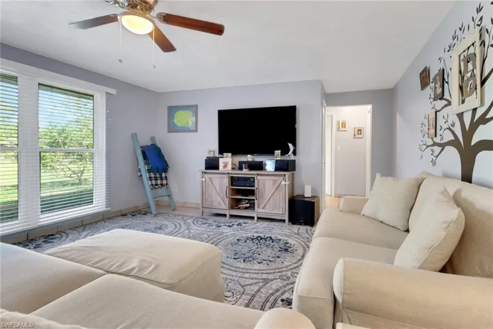 Tiled living room with baseboards and ceiling fan