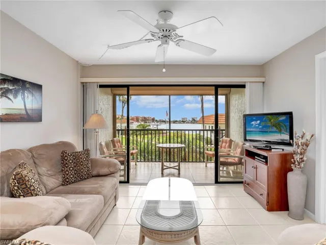 Living Room with Sliders to the Screened In Tiled Lanai with New Hurricane Shutter with Bay View