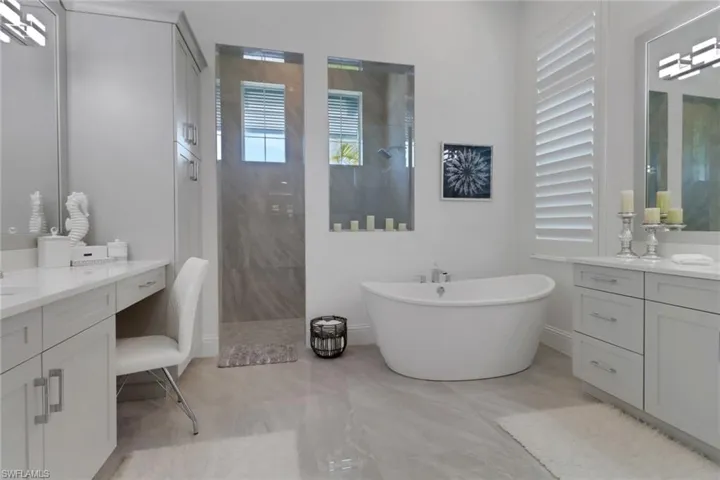 Primary on suite full bathroom with walk in shower, vanity, and a freestanding bath