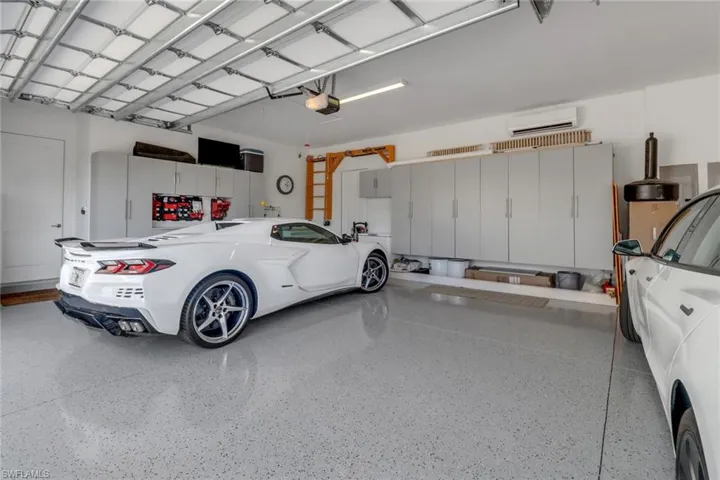 Garage with mini split AC and a insulated garage doors, walls and ceiling, custom cabinets, garage door openers