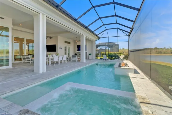 View of pool featuring a ceiling fan, a patio, a pool with connected hot tub, and a lanai