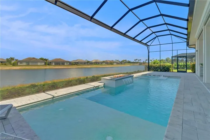 Pool view featuring a water view, a pool shelf for in pool sun bathing, water fall, fire feature, hot tub and a patio area.