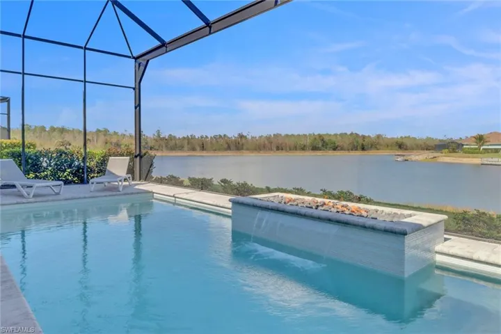 Swimming pool with a water view, a water fall, a fire feature and a patio area.