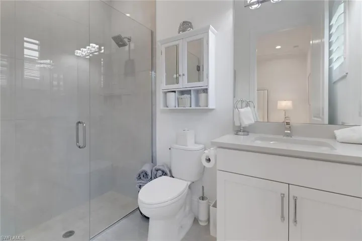 On suite bathroom for second bedroom with a shower stall and vanity