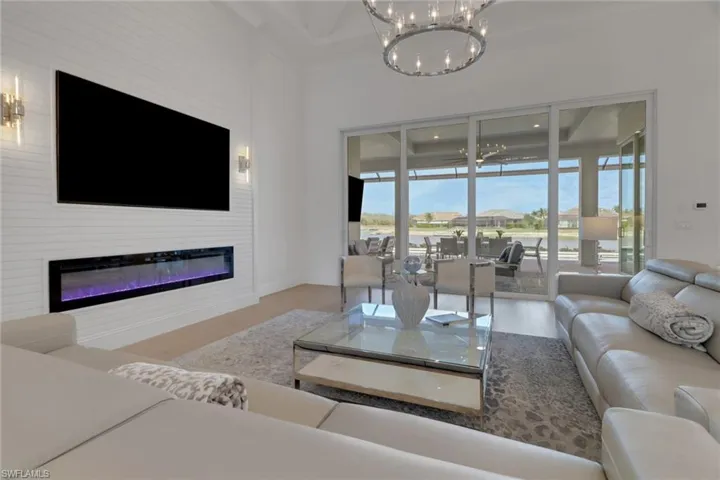 Living room featuring a chandelier, wood floors, healthy amount of natural light and glass sliding doors.