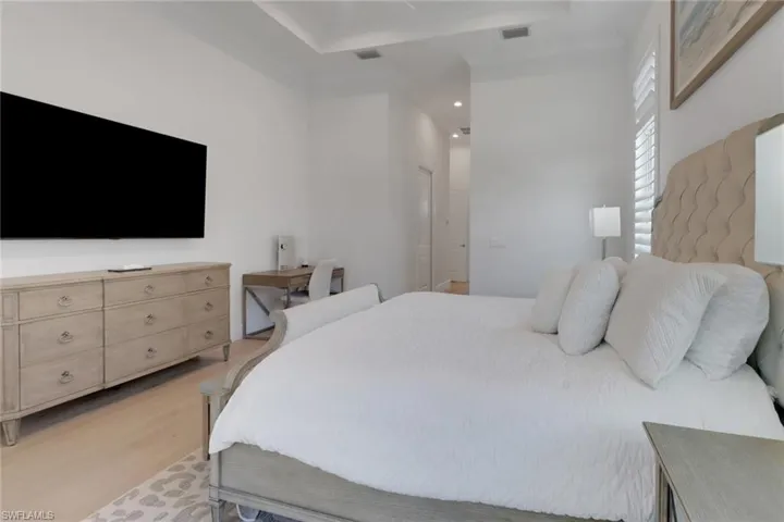 Primary Bedroom featuring light wood-style floors and a tray ceiling