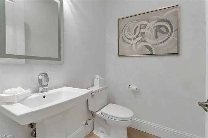 Guests powder room featuring pedestal sink and toilet.