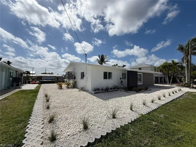 Back of property with stucco siding and a yard
