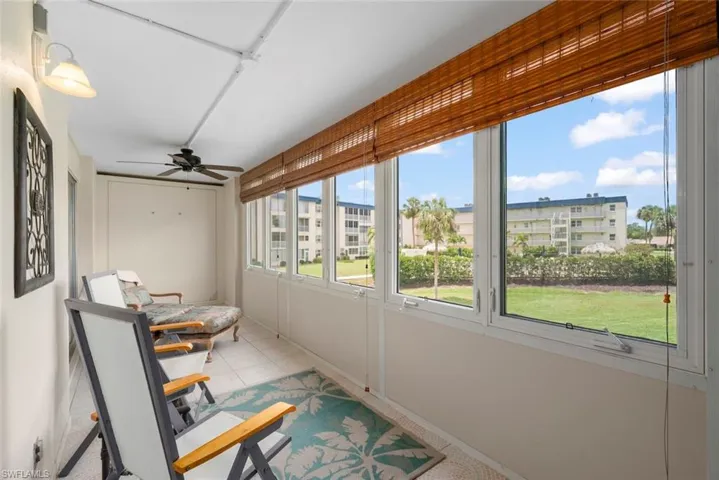 Sun room featuring a full wall of windows, tile flooring, and bamboo window treatments