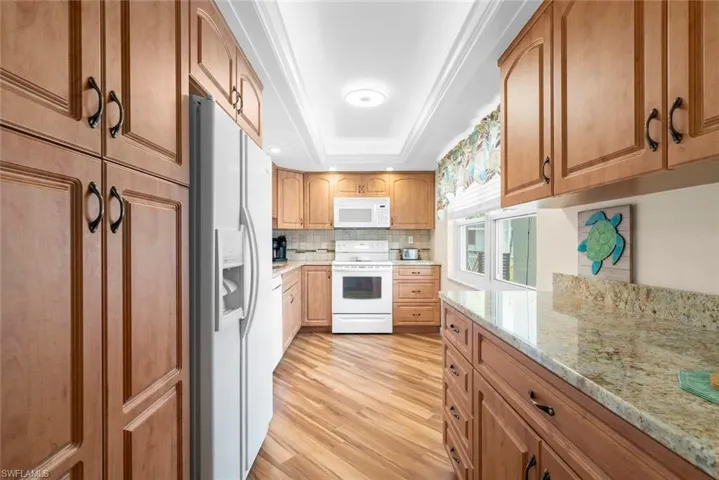 Kitchen featuring wood-finish flooring, wood cabinetry, and a tile backsplash