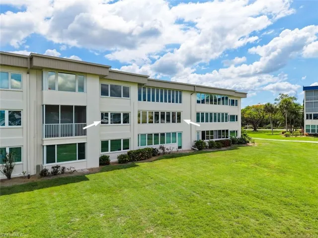 Back of the condo building featuring multiple windows