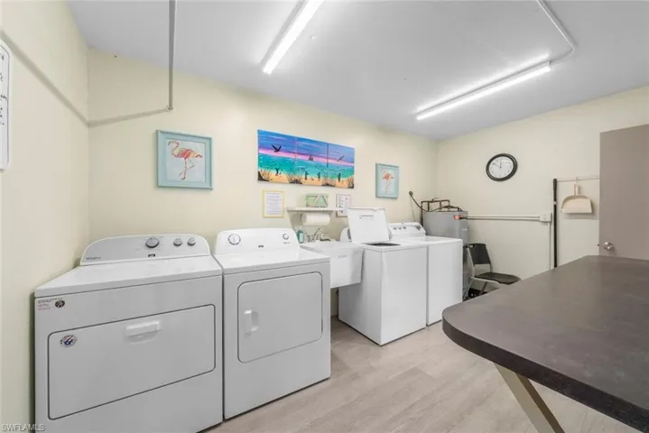 Dedicated laundry room featuring multiple washing machines and dryers, and utility sink.