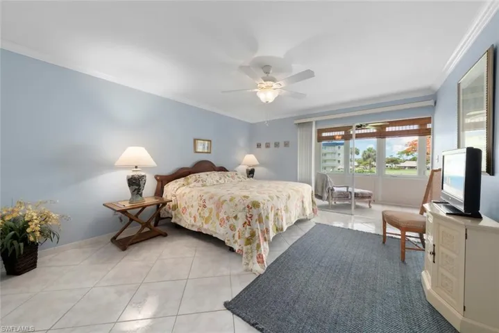 Primary bedroom suite with white crown molding and tile floors