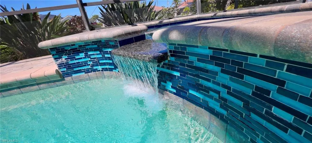View of swimming pool and hot tub with a lanai