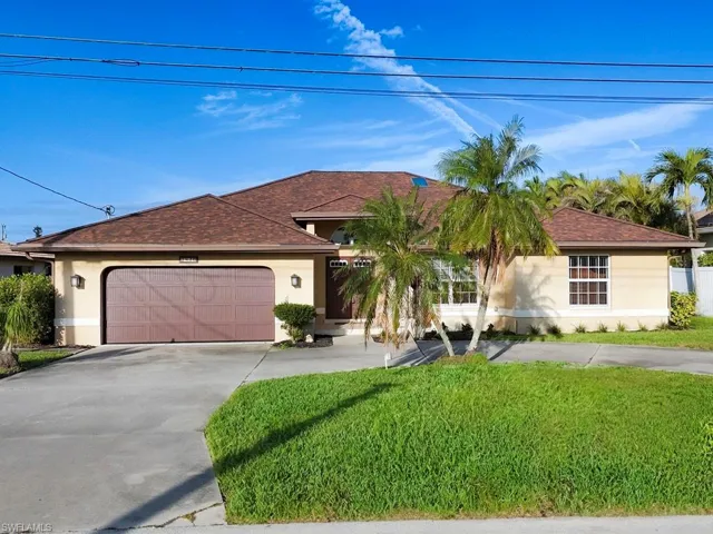 View of front of home featuring a garage, a front yard, concrete driveway, and stucco siding