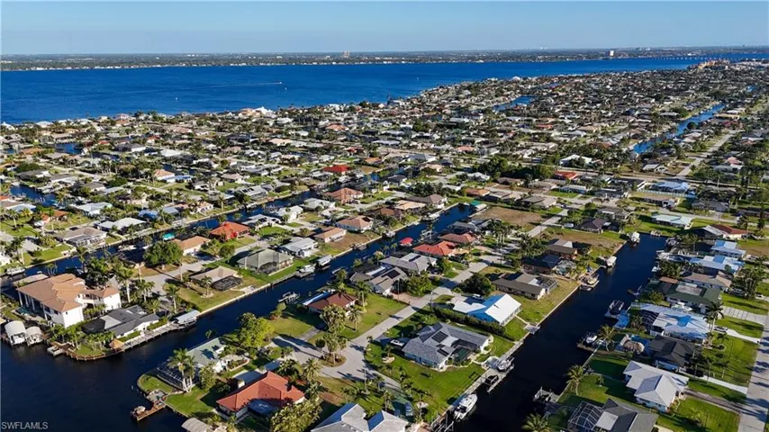 Drone / aerial view featuring a water view and surrounding community